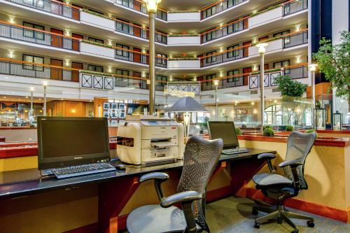 ein Büro mit zwei Computern auf einem Schreibtisch vor einem Gebäude in der Unterkunft Embassy Suites by Hilton Louisville East in Louisville