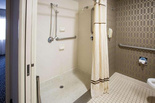 bagno con doccia e tenda doccia di Embassy Suites by Hilton Louisville East a Louisville