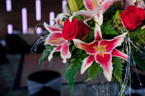 a vase filled with red and white flowers at DoubleTree by Hilton Hotel South Bend in South Bend