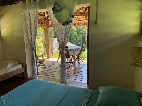 a bedroom with a bed and a view of a porch at Les Jardins d'Ankify in Ankify