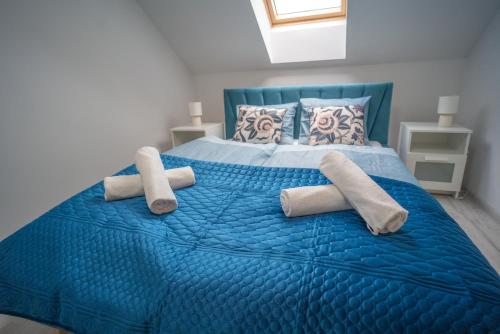 a blue bed with two towels and pillows on it at Szafirowe Oczko in Karpacz