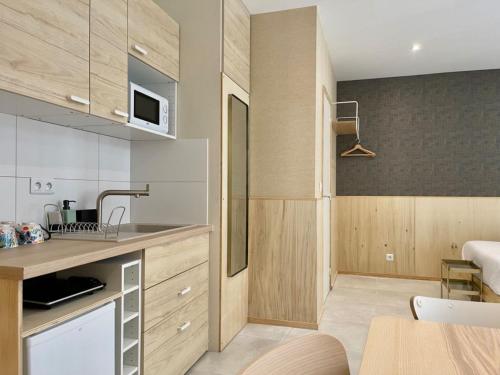 une cuisine avec des placards en bois et une salle à manger dans l'établissement Tang Home Apartment, à Bordeaux