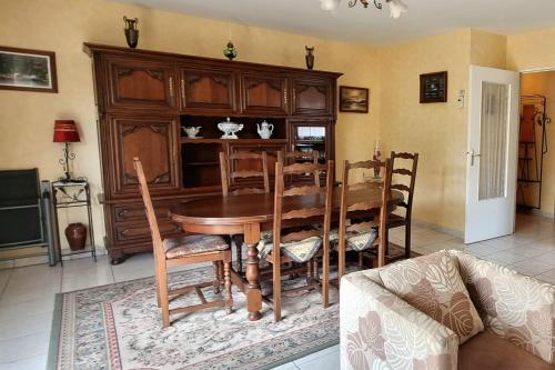 uma sala de jantar com uma mesa de madeira e cadeiras em A sparkling cocoon with a garden em Pleurtuit