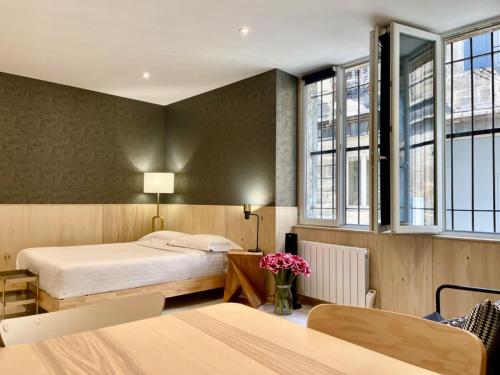 une chambre d'hôtel avec deux lits et des fenêtres dans l'établissement Tang Home Apartment, à Bordeaux