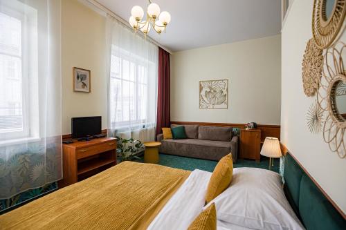 ein Wohnzimmer mit einem Bett und einem Sofa in der Unterkunft Hotel Arcus Garden in Bratislava