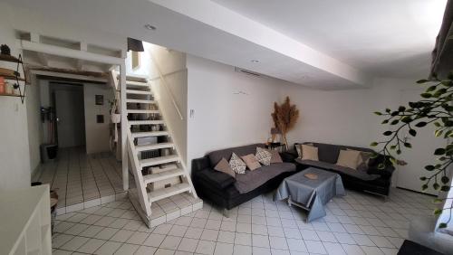 sala de estar con sofá y escalera de caracol en Appartement duplex sur les toits d'Aix avec terrasse ensoleillée, en Aix-en-Provence