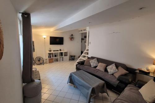 sala de estar con sofá y TV en Appartement duplex sur les toits d'Aix avec terrasse ensoleillée, en Aix-en-Provence