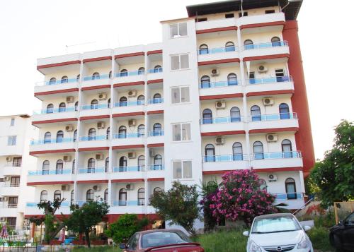 budynek z zaparkowanymi przed nim samochodami w obiekcie Hotel Royal w mieście Alanya