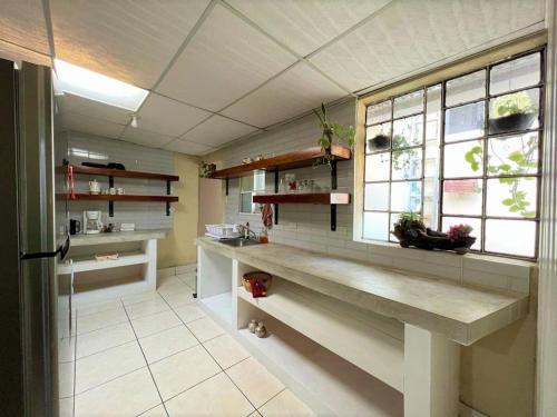 a kitchen with a counter and a window with plants at COZY Fully equipped private apartment in Chimaltenango