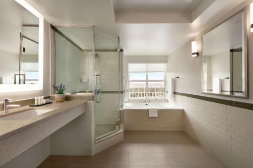 a bathroom with a glass shower and a sink at Embassy Suites by Hilton San Juan - Hotel & Casino in San Juan