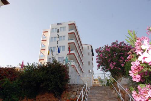 een wit gebouw met bloemen ervoor bij Hotel Royal in Alanya