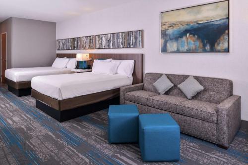 a hotel room with a bed and a couch at Hilton Garden Inn Salt Lake City Downtown in Salt Lake City