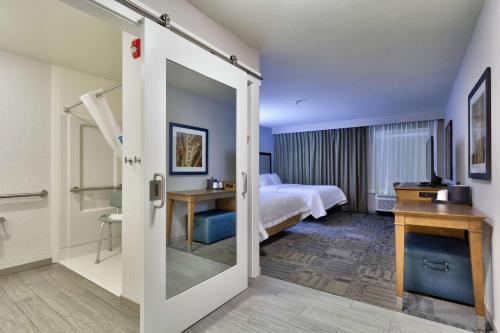 a hotel room with a bed and a television at Hampton Inn Salina in Salina