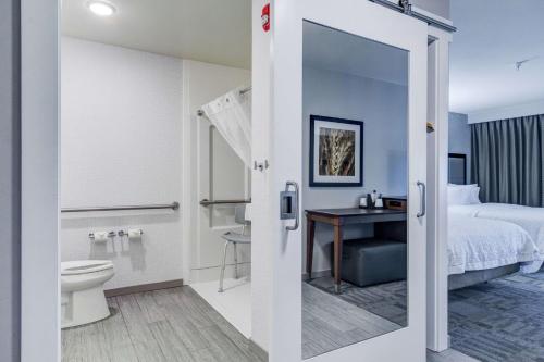 Cette chambre d'hôtel dispose d'une salle de bains avec un lit et des toilettes. dans l'établissement Hampton Inn Salina, à Salina