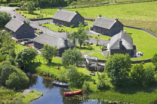 an aerial view of a village with boats in a river at Clan Cottages Luxury Thatched Retreat near Oban in Oban