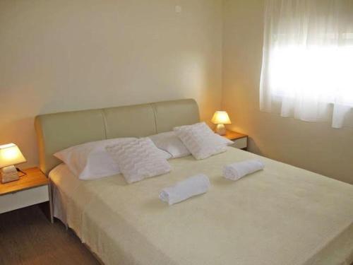 białe łóżko z 2 białymi poduszkami w obiekcie 4 bedroom apartment with 3 bathrooms and private parking - Apartments Orange w mieście Zadar