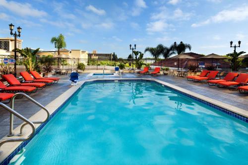 a large swimming pool with red lounge chairs in a resort at DoubleTree Suites By Hilton Anaheim Resort/Convention Center in Anaheim
