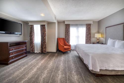 a hotel room with a bed and a flat screen tv at Homewood Suites by Hilton Olmsted Village in Pinehurst