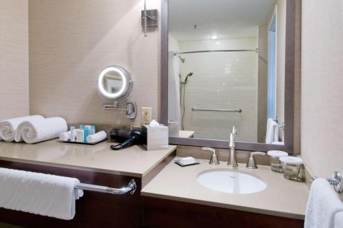 a bathroom with a sink and a large mirror at Hilton Saint John in Saint John