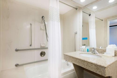 a bathroom with a shower and a sink and a tub at Hampton Inn West Springfield in West Springfield