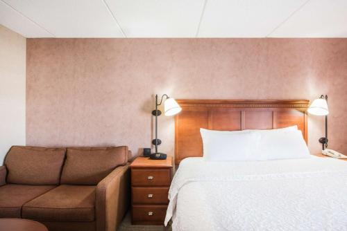 a bedroom with a bed and a couch at Hampton Inn West Springfield in West Springfield