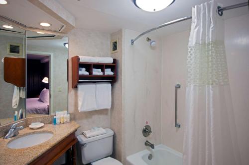 a bathroom with a shower and a toilet and a sink at Hampton Inn West Springfield in West Springfield