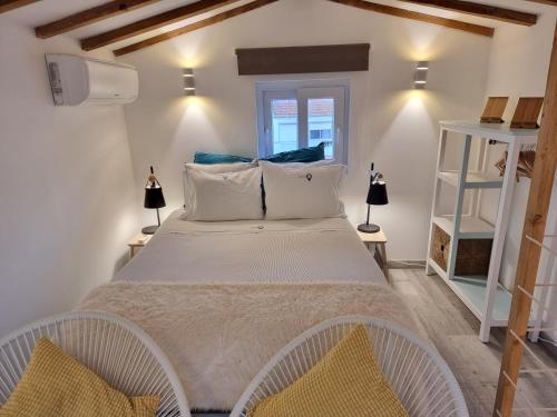 1 dormitorio con 1 cama grande y 2 lámparas en Vila Maria Apartments by Host-Point, en Costa da Caparica