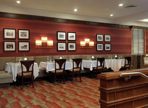 een eetkamer met tafels en stoelen en schilderijen aan de muur bij DoubleTree by Hilton Collinsville/St.Louis in Collinsville