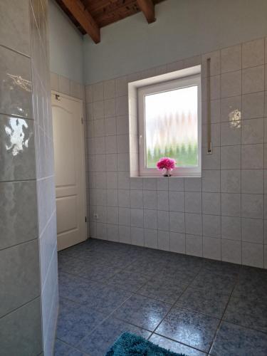 a bathroom with a pink flower in a window at Ferienwohnung Bayernbrise in Rohrdorf