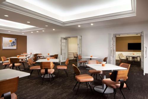 Un comedor con mesas y sillas y un televisor. en Hilton St. Petersburg Bayfront, en San Petersburgo