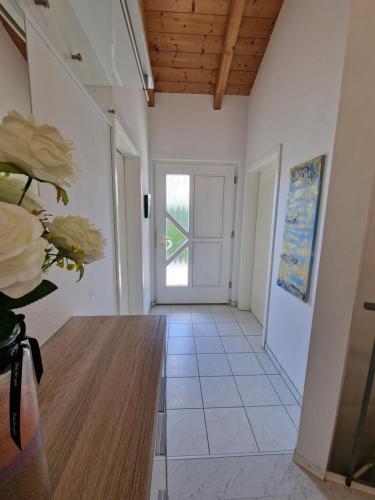 a hallway with a door and a vase of flowers at Ferienwohnung Bayernbrise in Rohrdorf