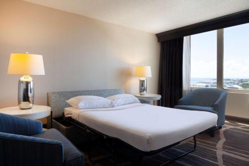 a hotel room with a bed and two chairs at Hilton St. Petersburg Bayfront in St. Petersburg