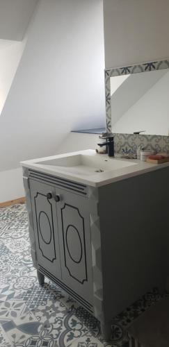 a bathroom vanity with a sink and a mirror at chambre chez l'habitant in Mauléon-Licharre