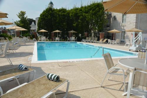 a swimming pool with chairs and a table and an umbrella at Hilton St. Louis Frontenac in Frontenac