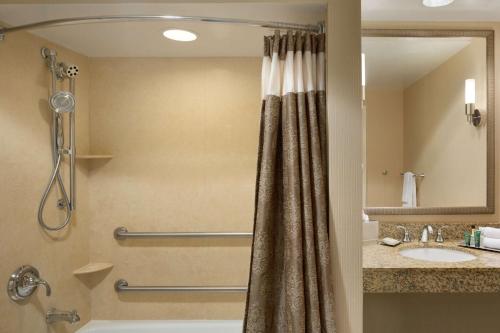 a bathroom with a shower with a shower curtain at Hilton St. Louis Frontenac in Frontenac