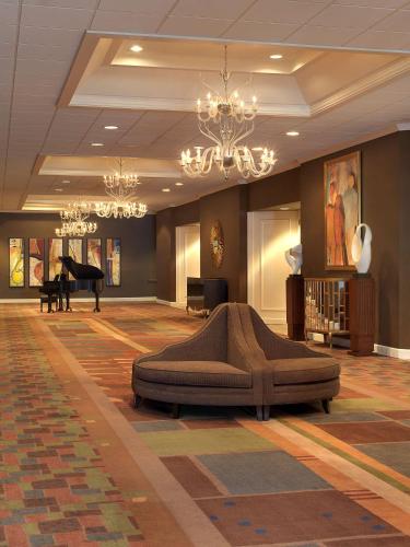 a lobby with a large couch in the middle of a room at Hilton St. Louis Airport in Woodson Terrace