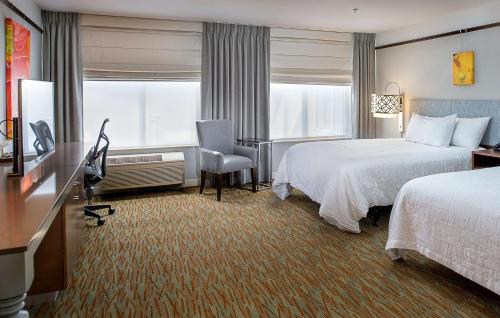 a hotel room with two beds and a desk at Hilton Garden Inn St. Louis/O'Fallon in O'Fallon