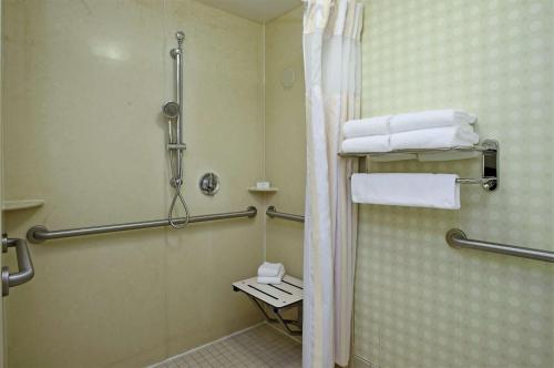 a bathroom with a shower and a toilet and towels at Hilton Garden Inn Sonoma County Airport in Santa Rosa