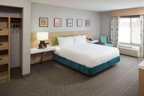 a bedroom with a bed and a desk with a lamp at Hilton Garden Inn Sioux City Riverfront in Sioux City