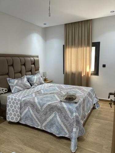 a bedroom with a bed with a blanket on it at Appartement en m'diq centre ville près de la plage in M'diq
