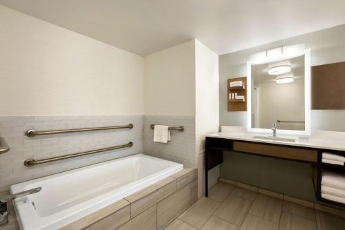 a bathroom with a bath tub and a sink at Hilton Garden Inn Tifton in Tifton