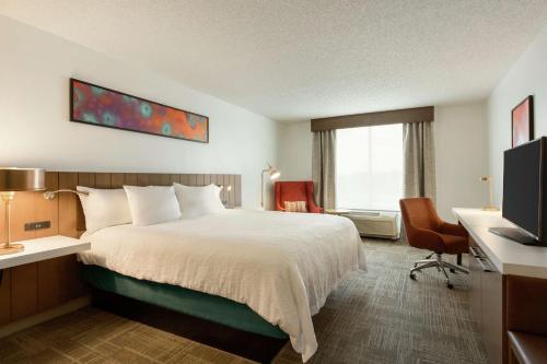 a hotel room with a bed and a television at Hilton Garden Inn Tifton in Tifton