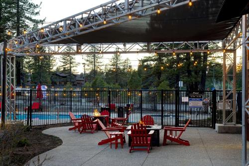 un patio con sedie rosse, tavoli e recinzione di Hampton Inn & Suites Tahoe-Truckee a Truckee