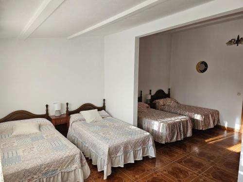 Habitación con 3 camas en una habitación en As Rosas apartamentos, en Cambados