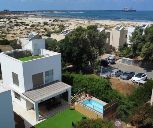 a house with a swimming pool and a beach at הבית בחוף הזהב in Caesarea