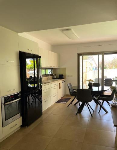 a kitchen with a table and chairs and a dining room at הבית בחוף הזהב in Caesarea