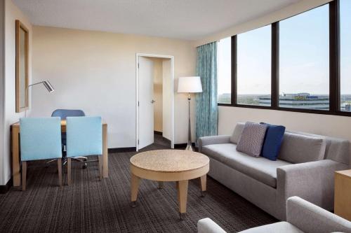 a hotel room with a couch and a table and window at Embassy Suites by Hilton Tampa Airport Westshore in Tampa