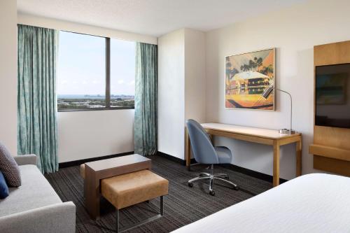 a hotel room with a desk and a bed at Embassy Suites by Hilton Tampa Airport Westshore in Tampa