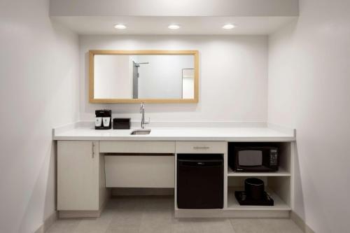 a bathroom with a sink and a microwave at Embassy Suites by Hilton Tampa Airport Westshore in Tampa