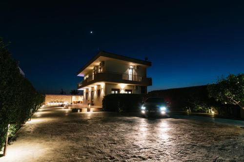 une voiture garée devant une maison la nuit dans l'établissement SandShine Luxury Villa, à Kalamaki